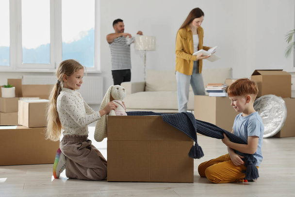 Happy family settling into new house and unpacking boxes. Moving day - Valokuva, kuva