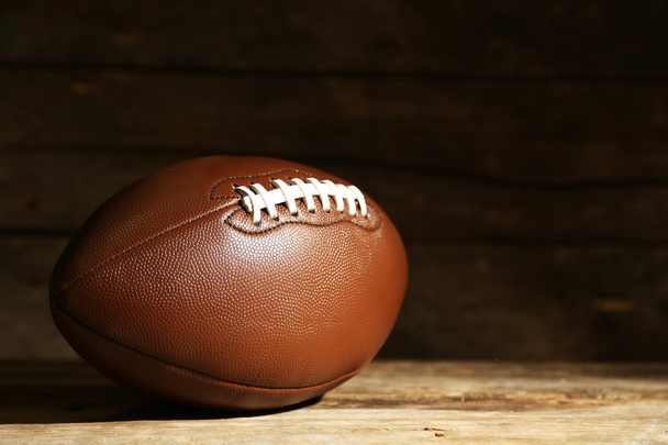 American football on wooden table, close up - 写真・画像