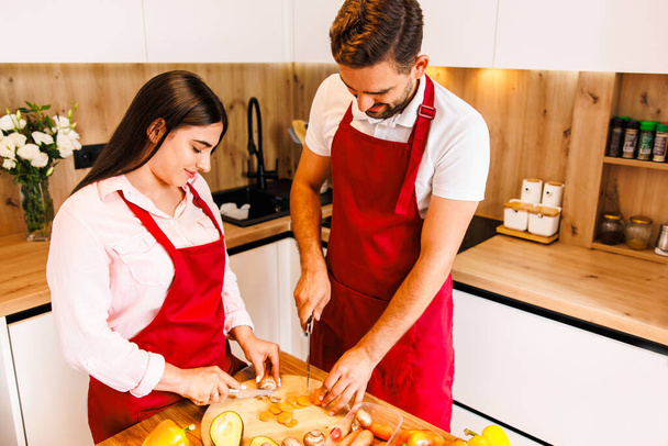 Young couples are happily choosing the ingredients or raw material before cooking dinner in the kitchen.Happy family concept.Healthy lifestyle. High quality photo - Фото, зображення
