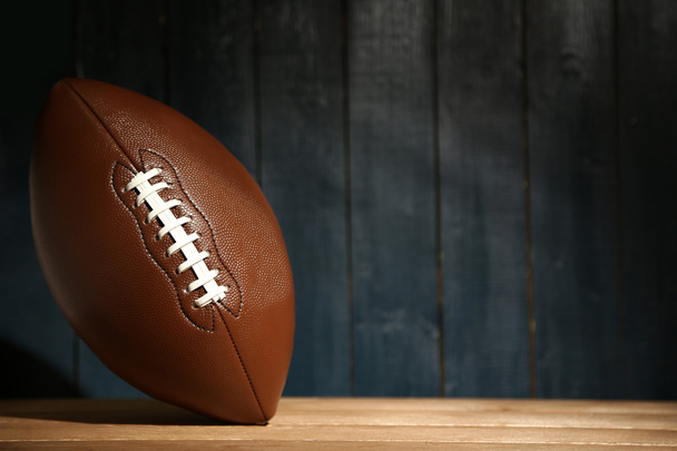 American football on wooden table, close up - 写真・画像