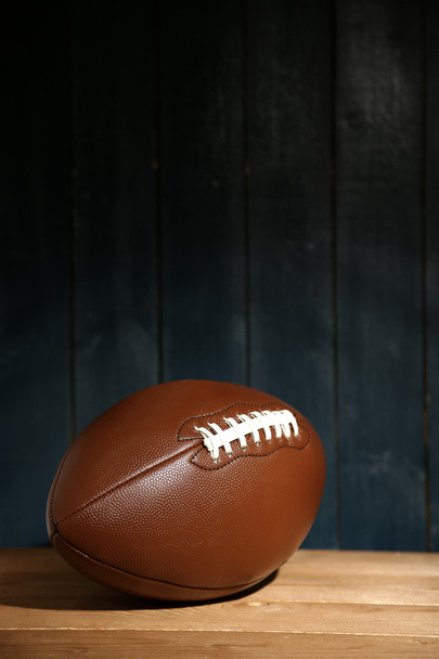 American football on wooden table, close up - Фото, изображение