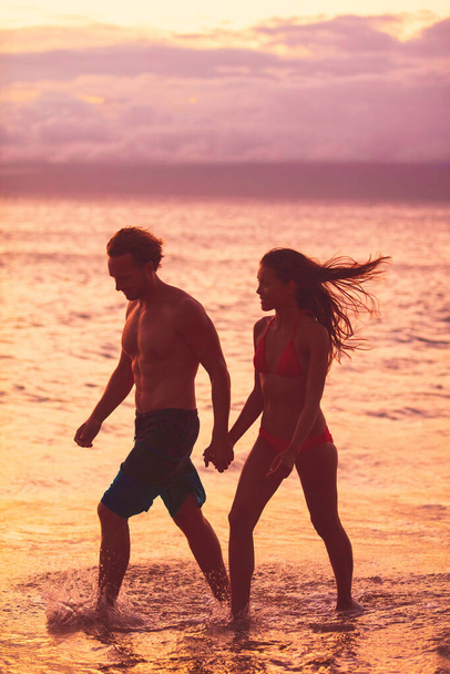 Beach couple walking on romantic sunset summer travel vacation silhouettes Sunset Caribbean tropical destination holidays woman and man young lovers relaxing on romance getaway. - Фото, зображення