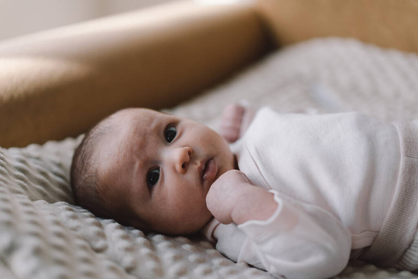 Portrait of a 1 month old baby. Cute newborn baby lying on a developing rug. Love baby. Newborn baby and mother. - Φωτογραφία, εικόνα