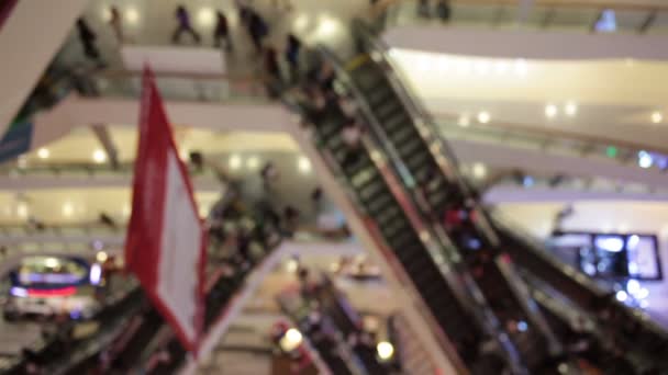 abstract Blur achtergrond van winkelcentrum en menigte van wandelen mensen gebruiken roltrap in het winkelcentrum centrum met bokeh - Video