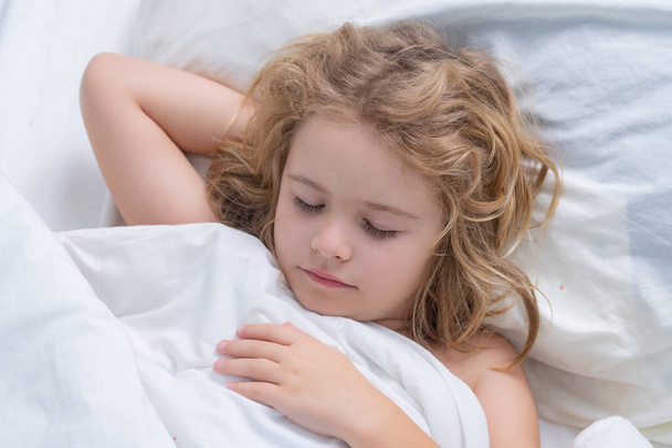 Sleep, sleeping concept. Kid sleeping on bed at home. Bedtime, kids sleeps. Child asleep on pillow, having healthy sleep - Фото, изображение