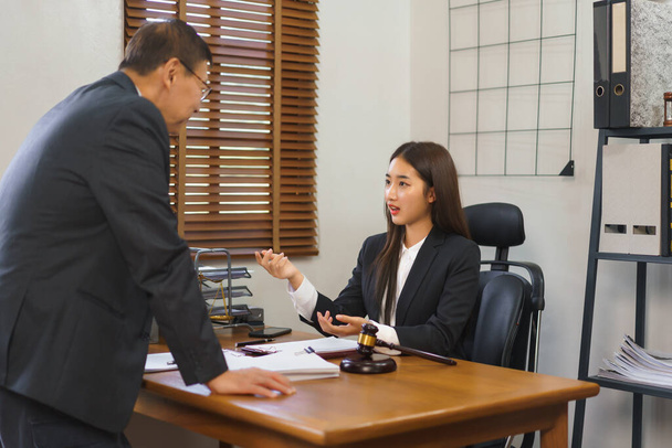 Law and justice concept, Female lawyer showing contract to explains and consults with senior lawyer. - Photo, image