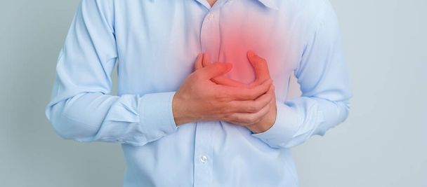man hand holding chest ache. Heart disease, angina disease and symptom heart attack disease Cardiovascular, Atherosclerosis, Hypertensive world Heart day and health concept - Zdjęcie, obraz