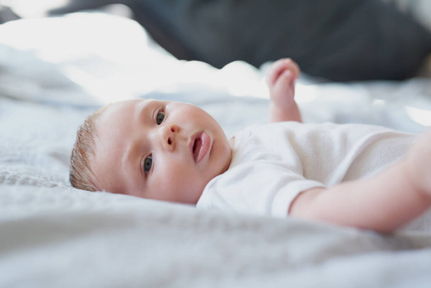 Schattig wordt niet schattiger dan dit. een schattige baby jongen liggend op een bed thuis - Foto, afbeelding