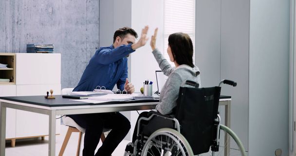 Geschäftsfrau mit Behinderung gibt ihrem Partner im Büro High Five - Foto, Bild
