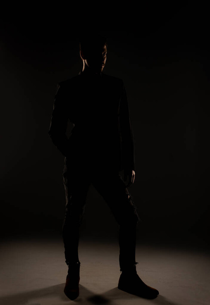 Homme attrayant posant devant la caméra avec un angle légèrement incliné dans le studio - Photo, image