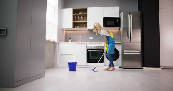 Happy Woman Cleaning Floor With Mop In Kitchen At Home - Photo, image