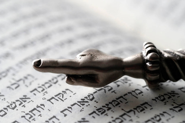 Um ponteiro ritual judeu Yad prateado numa Torá. Símbolo religioso.  - Foto, Imagem