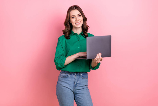 Photo of pleasant satisfied nice woman with wavy hairdo dressed green shirt hold laptop while working remotely isolated on pink background. - Photo, Image
