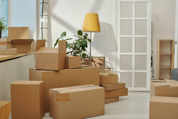 Vodorovný obraz lepenkových krabic stojících v místnosti a připravujících se k pohybu - Fotografie, Obrázek