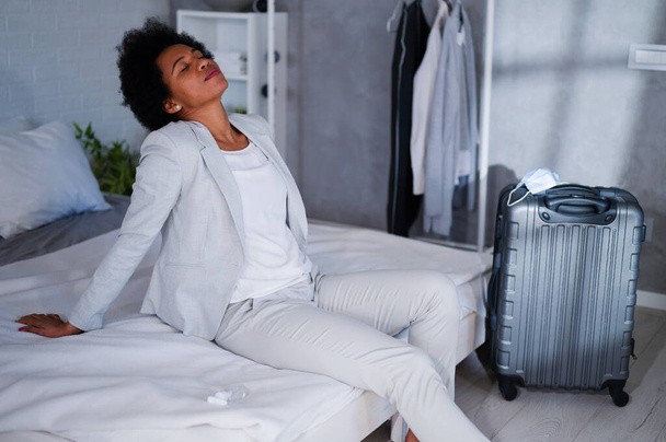 Black woman traveler, exhausted from a trip on bed - Photo, Image
