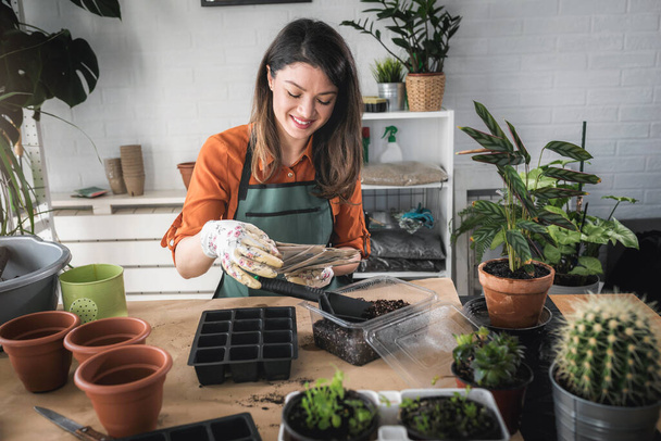 Mujer cuidando plantas en su casa.  - Foto, Imagen