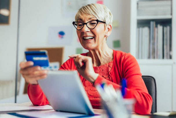 Senior Woman At Home Nákup produktů nebo služeb Online pomocí digitální tablety a kreditní karty - Fotografie, Obrázek