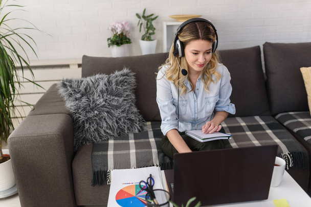Young woman with headset working from home having online consultations - Photo, Image