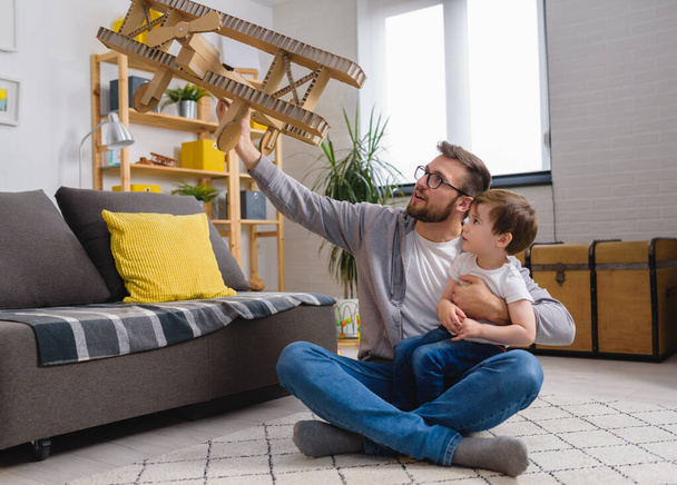 Padre e figlio bambino che giocano con l'aeroplano di cartone - Foto, immagini