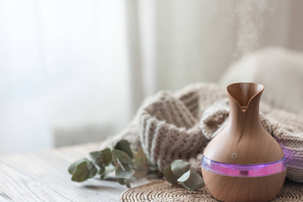 Spa composition with aroma oil diffuser lamp on a blurred background in the interior of the room, copy space. - Photo, Image
