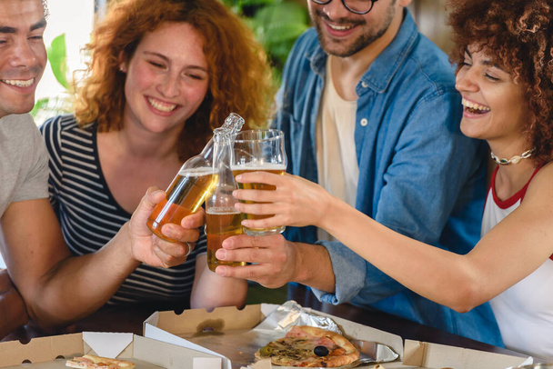 Freunde essen Pizza und trinken Bier - Foto, Bild