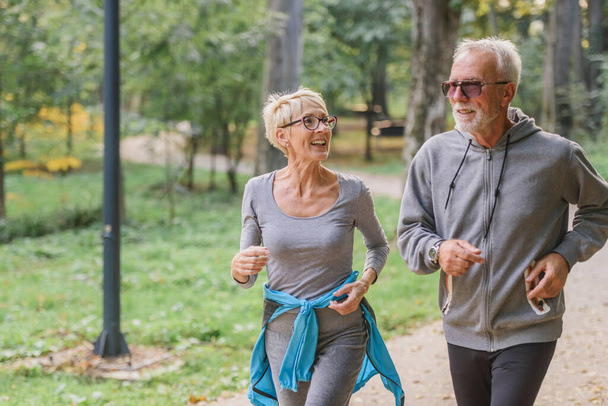 Veselý, aktivní starší pár běhající v parku. Cvičení společně zastavit stárnutí. - Fotografie, Obrázek