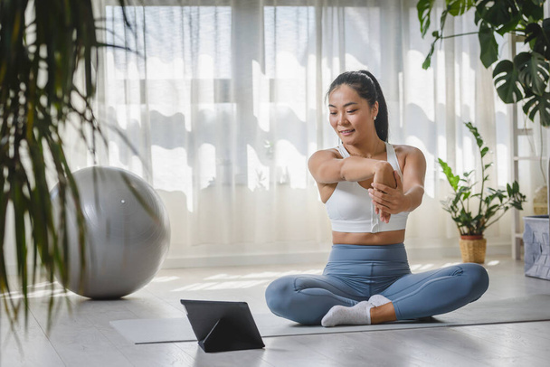 bella giovane donna che fa esercizi di yoga su stuoia in soggiorno  - Foto, immagini