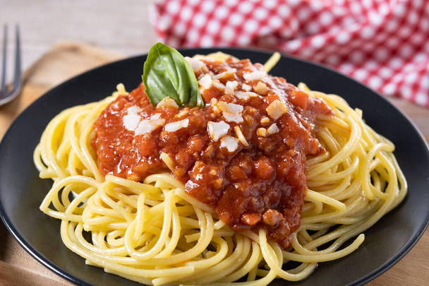 Spaghetti with bolognese sauce on wooden table - Fotó, kép