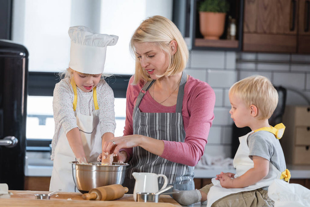 happy mother cooking with daughter and son - Photo, Image