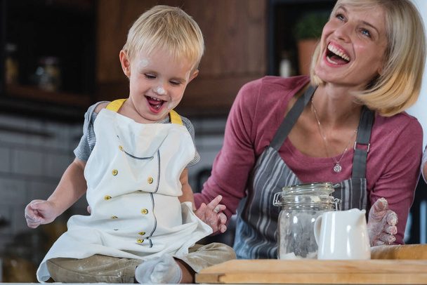 Μητέρα ξοδεύει ποιοτικό χρόνο με ένα παιδί στην κουζίνα, ψήνοντας ένα κέικ - Φωτογραφία, εικόνα