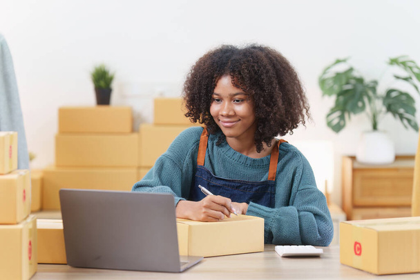 Amerikaanse Afrikaanse ondernemer glimlach en het controleren van online bestelling. Succesvol MKB-ondernemersconcept. - Foto, afbeelding