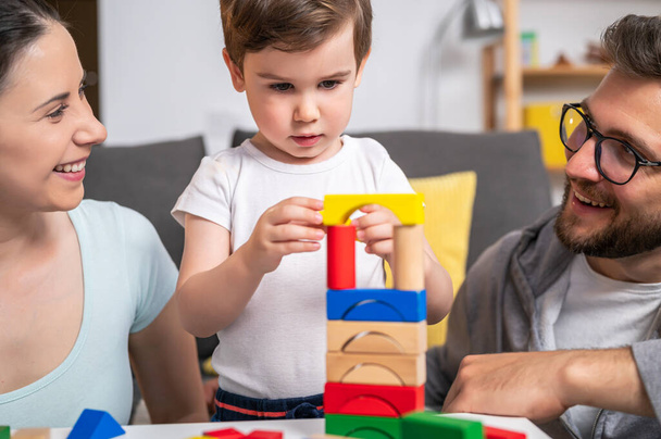 familia joven jugando con bloques de madera de juguete en casa - Foto, imagen