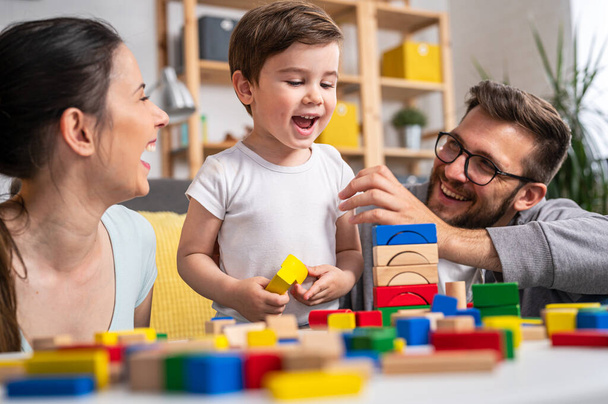 familia joven jugando con bloques de madera de juguete en casa - Foto, imagen