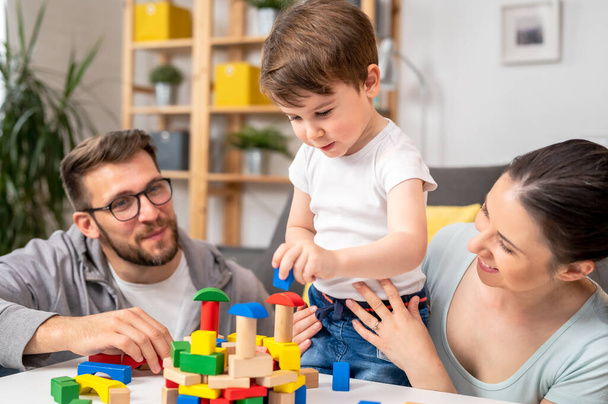 young family playing with toy wooden blocks at home - Photo, Image