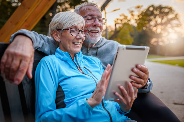 Dışarıda tablet kullanan mutlu yaşlı çift. - Fotoğraf, Görsel