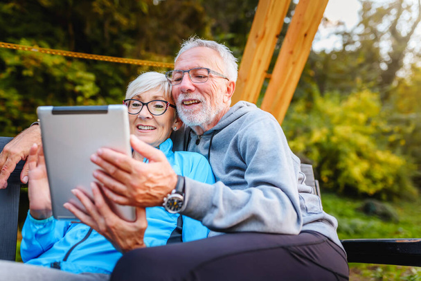 casal sênior feliz usando tablet ao ar livre - Foto, Imagem