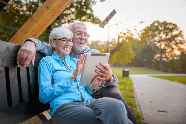 heureux couple de personnes âgées en utilisant la tablette à l'extérieur - Photo, image