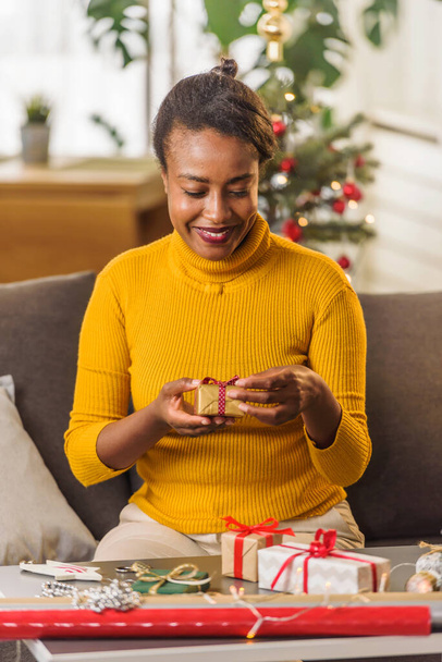 african american woman preparing for holidays, wrapping gifts - Zdjęcie, obraz