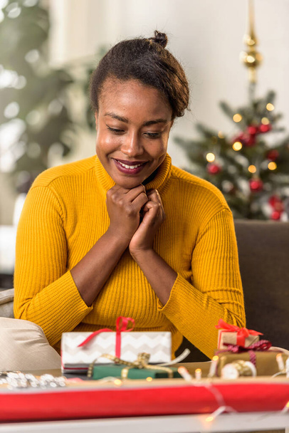 african american woman preparing for holidays, wrapping gifts - Foto, Imagem