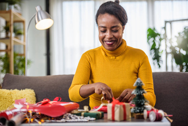 african american woman preparing for holidays, wrapping gifts - Photo, Image