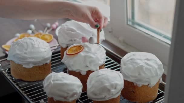 Ένα λευκό γυναικείο χέρι αποκωδικοποιεί φρεσκομαγειρεμένα πασχαλινά κέικ. Μαγείρεμα χειροποίητα παραδοσιακά κέικ Πάσχα - Πλάνα, βίντεο