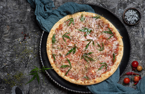 Happy pizza. Pizza with cannabis decorated with marijuana leaves top view - Foto, Bild