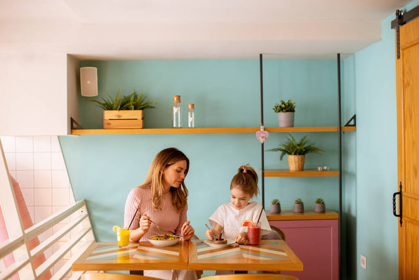 Мать и дочь хорошо проводят время за завтраком со свежими соками в кафе - Фото, изображение