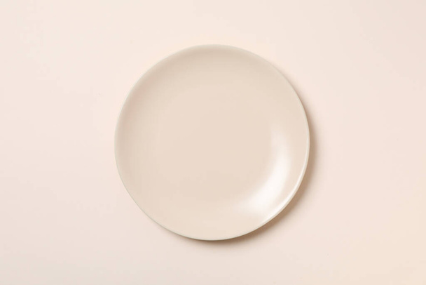 Empty plate on beige background, top view - 写真・画像
