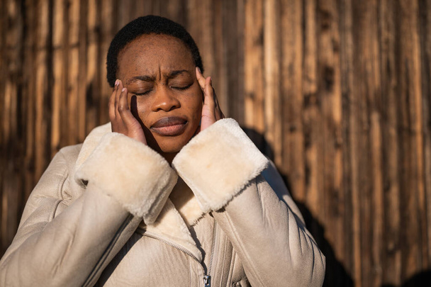 Portrait extérieur de femme afro-américaine. Elle est fatiguée et a mal à la tête.. - Photo, image