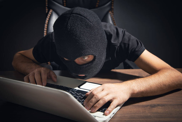  Hacker robando información de la computadora de la oficina. Hacking, Criminal - Foto, imagen