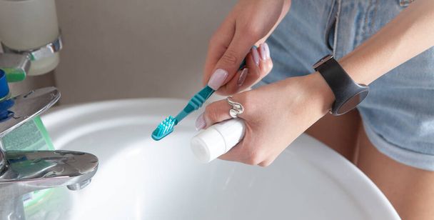 Jovem mulher segurando escova de dentes antes de escovar os dentes. - Foto, Imagem