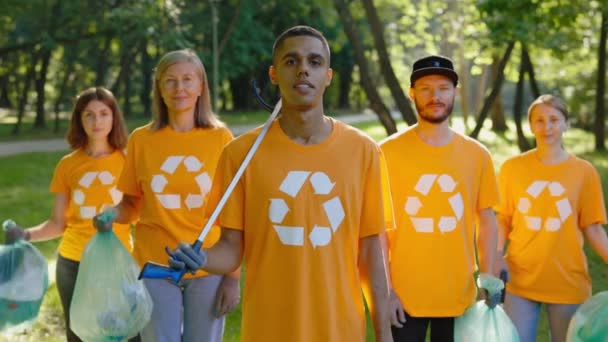 Portrét dobrovolníků skupiny Eco po vyčištění lesa od odpadků. Týmoví ekologičtí aktivisté pracující ve veřejné zahradě. Ekologický problém - Záběry, video