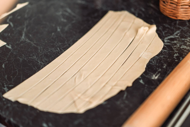 Puff pastry cut into strips on a tabletop. - Photo, Image