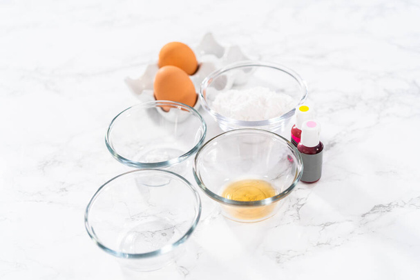 Измеренные ингредиенты в стеклянных мисках для выпечки пасхальных безе печенье. - Фото, изображение